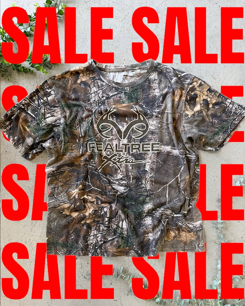 Vintage camo clothing collection featuring RealTree t-shirts, military jackets, and rugged outdoor workwear from the 90s and early 2000s.